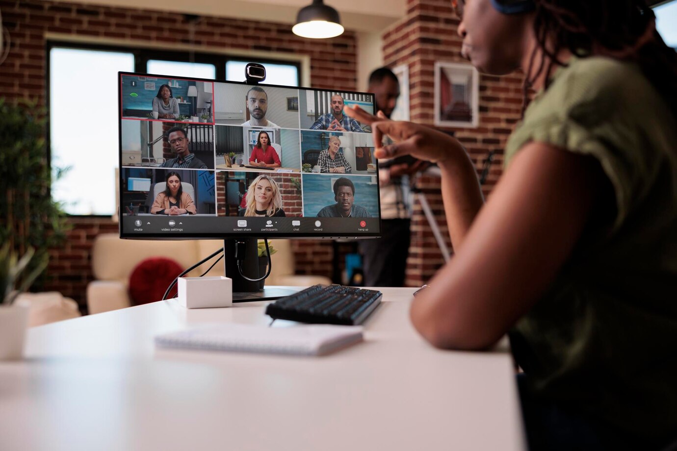 selective-focus-computer-screen-with-startup-team-startup-employees-working-remote-group-video-call-brainstorming-ideas-african-american-woman-gesturing-internet-meeting-with-colleague